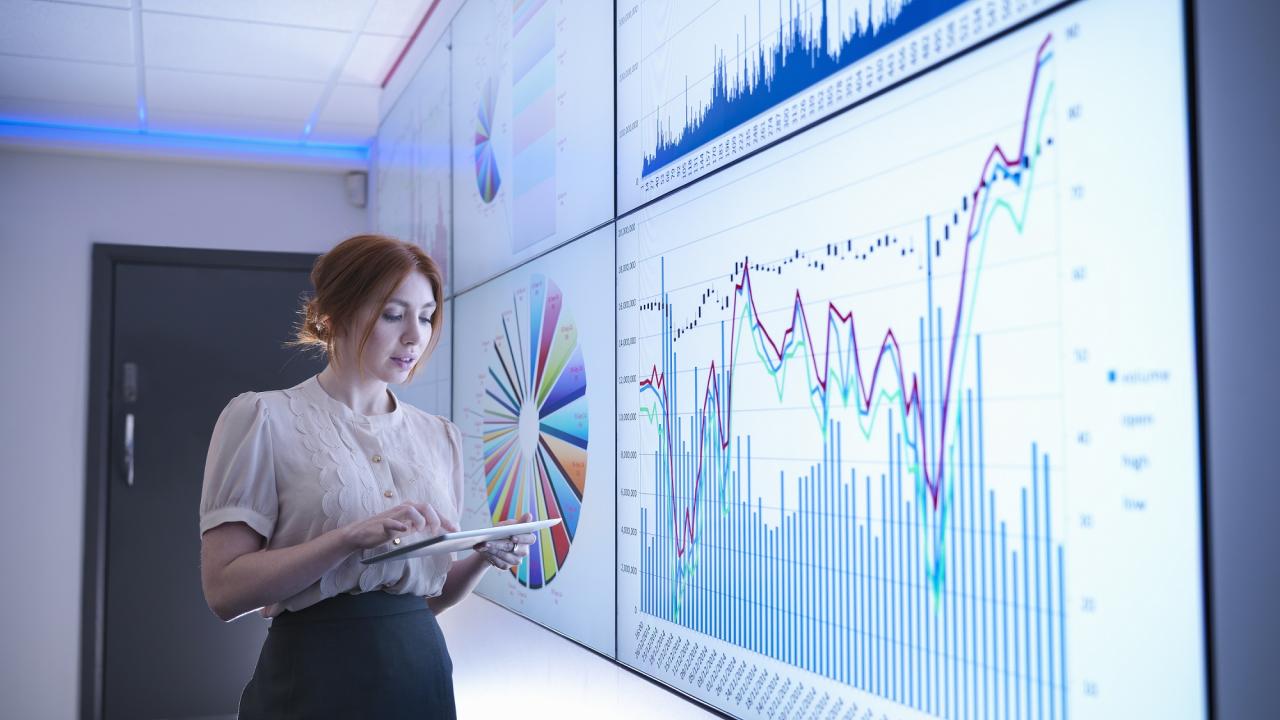Woman analyzing data on large screens