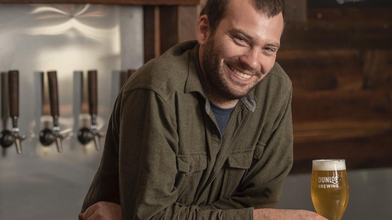 Brennan Fleming at his bar with beer