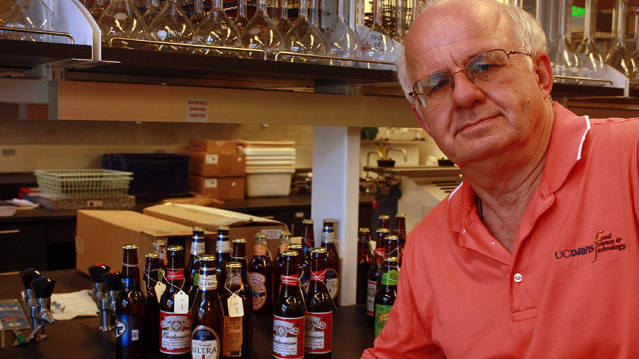 Brewing expert Charlie Bamforth poses with bottles of beer