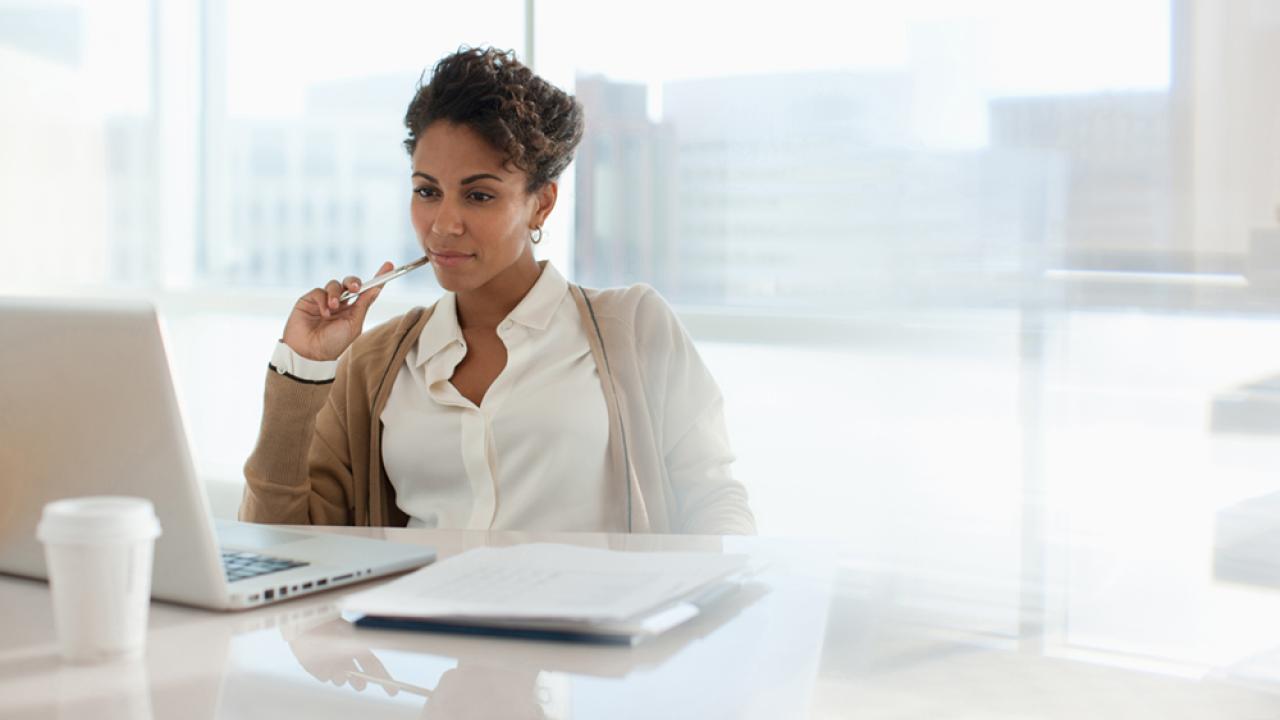 woman sitting at desk looking at computer