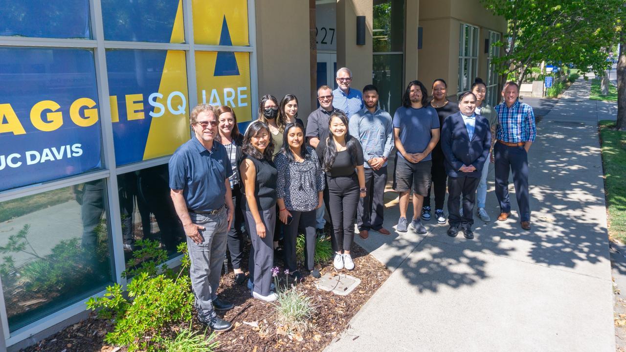 UC Davis Tech Pathways students stand in a group outside at Aggie Square