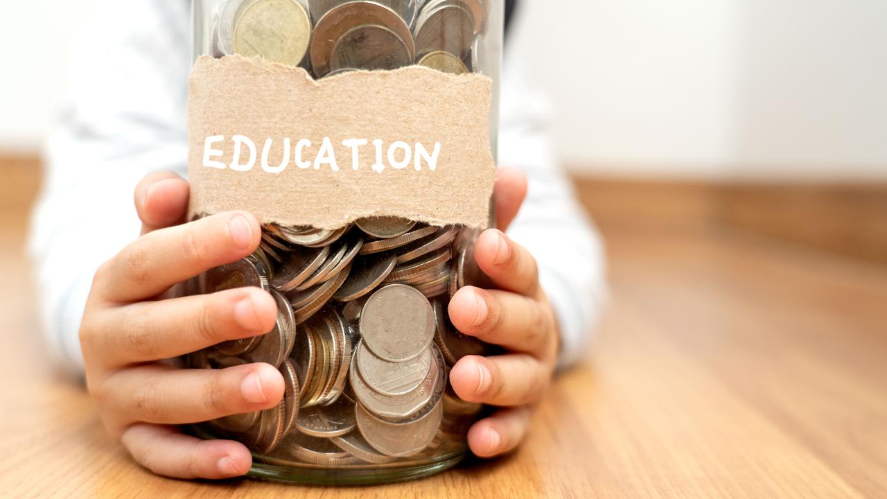 glass jar with money and education sign on it