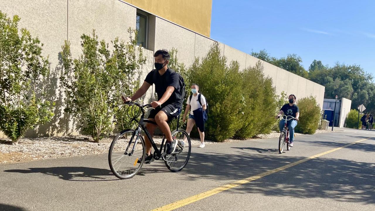students riding bikes on campus