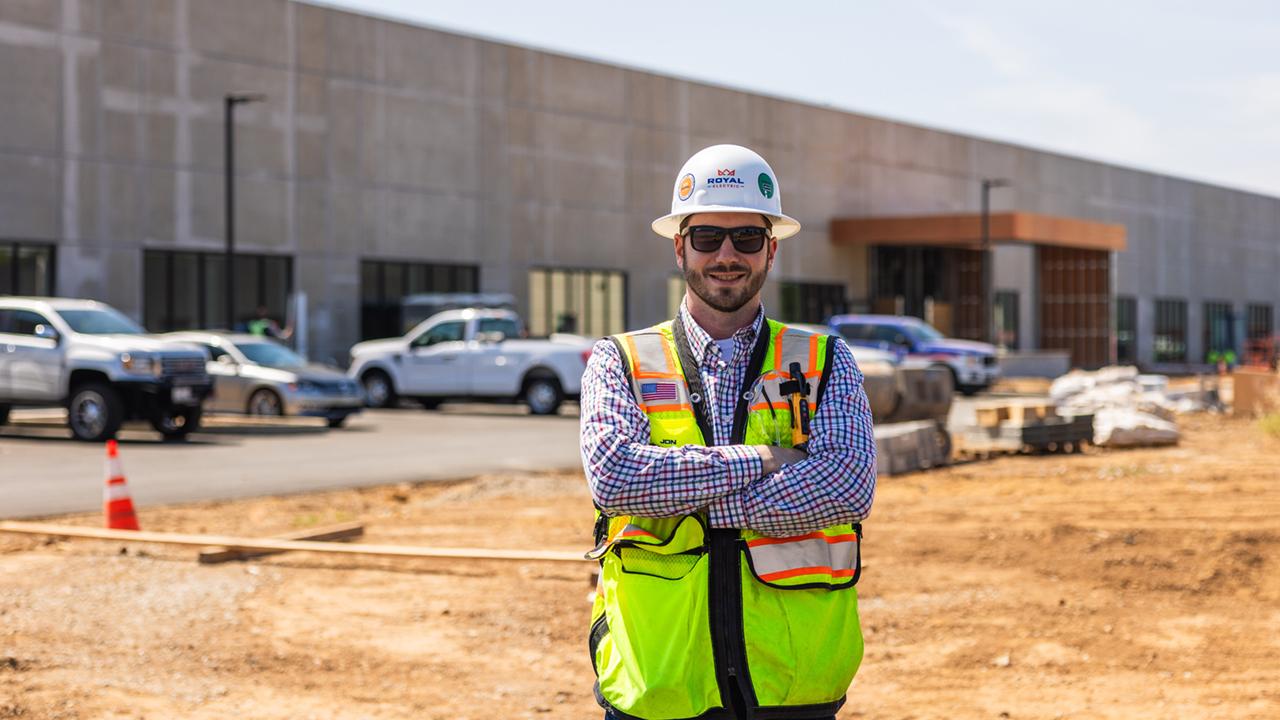 UC Davis Construction Management grad, Jon Davis, poses in front of a construction site