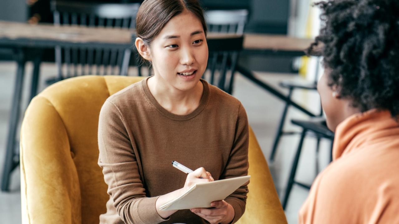 Coach taking down notes talking with client