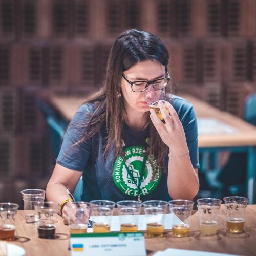 Lana Svitankova sits in front of beer samples and smells a sample during judging