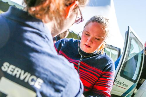 emt and woman using stethoscope
