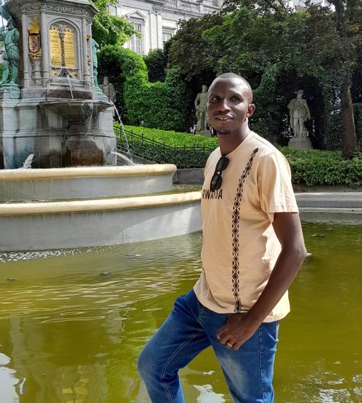 UC Davis Coursera student Theogene Semana poses in front of fountain in Bruxuels