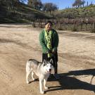 UC Davis Winemaking Certificate program grad Purnima Sreenivasan poses with her dog in a vineyard