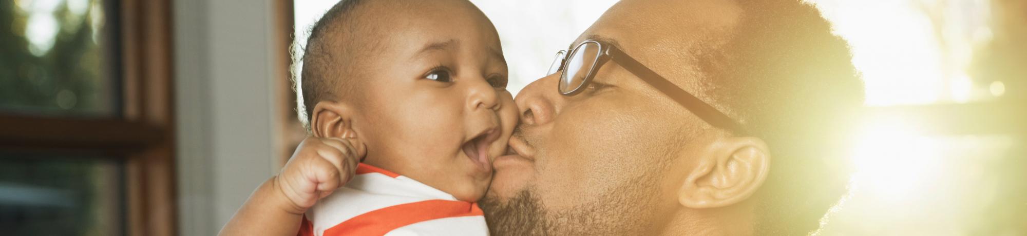 Father kissing infant