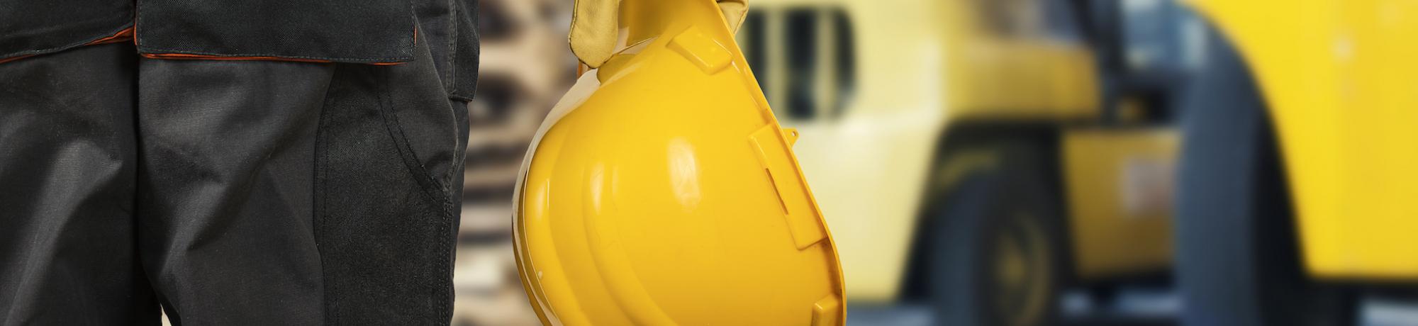 person holding a hard hat at a job site